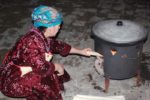 Feeding the fire under the plov. Photo credit: Marina Karptsova
