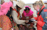 Sharing polaroid pictures with new friends in Tibet. Photo credit: Russ Cmolik & Ellen Cmolik.