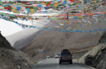 Passing under strings of Tibetan prayer flags. Photo credit: Russ Cmolik & Ellen Cmolik