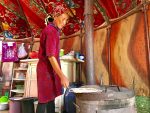 Fresh off the grill — a Kyrgyz woman toasts nan flatbread. Photo credit: Michel Behar