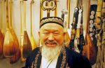 A happy face amid traditional Kazakh musical instruments in Almaty. Photo credit: Michel Behar