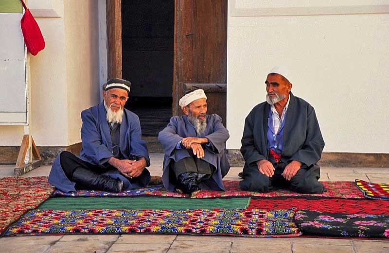 Older Bukharans converse in typical Uzbek style: often cross-legged, seated on Central Asian carpets. Photo credit: Michel Behar